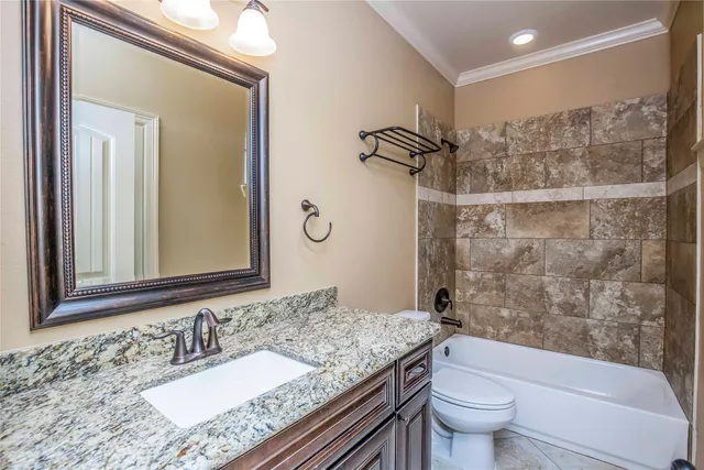 a bathroom with a granite countertop sink toilet mirror and shower