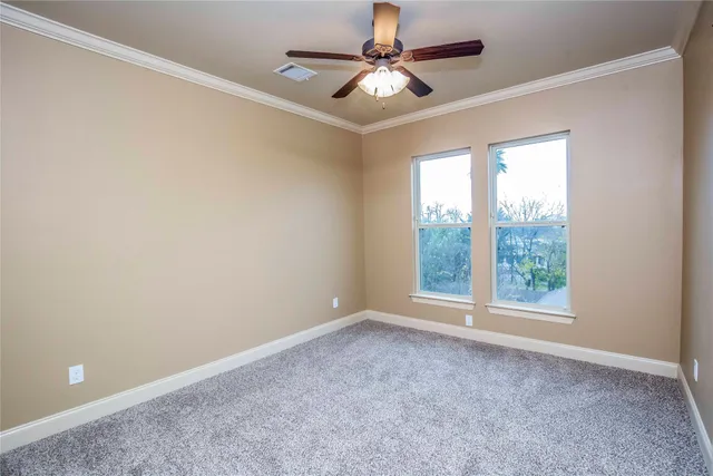 an empty room with closet and a ceiling fan