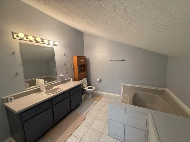 a bathroom with a tub sink and mirror
