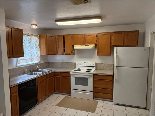 a kitchen with a stove sink and refrigerator