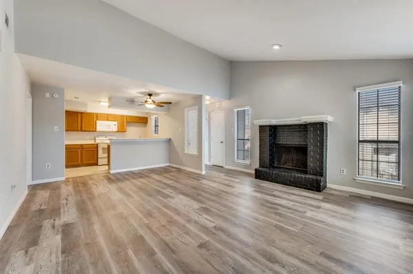 a view of an empty room with a fireplace and a window