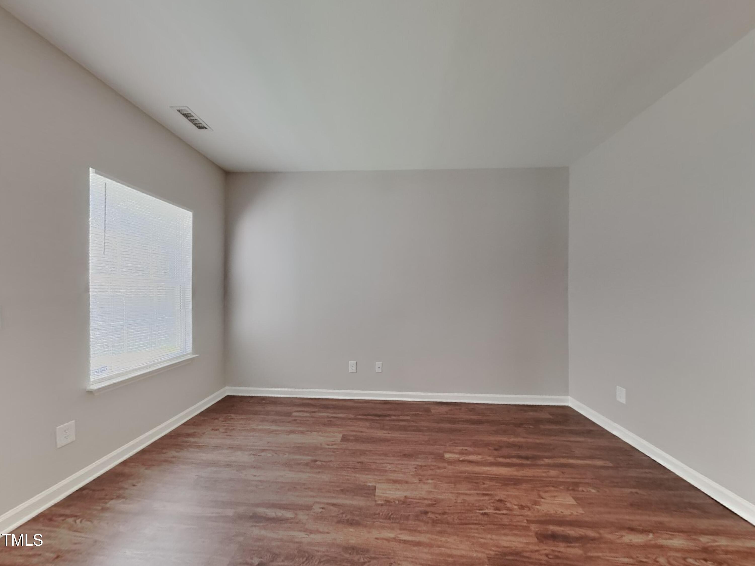 5416 Neuse Forest Road Raleigh, NC 27616 - Photo 3 of 15 a view of an empty room with wooden floor and a window