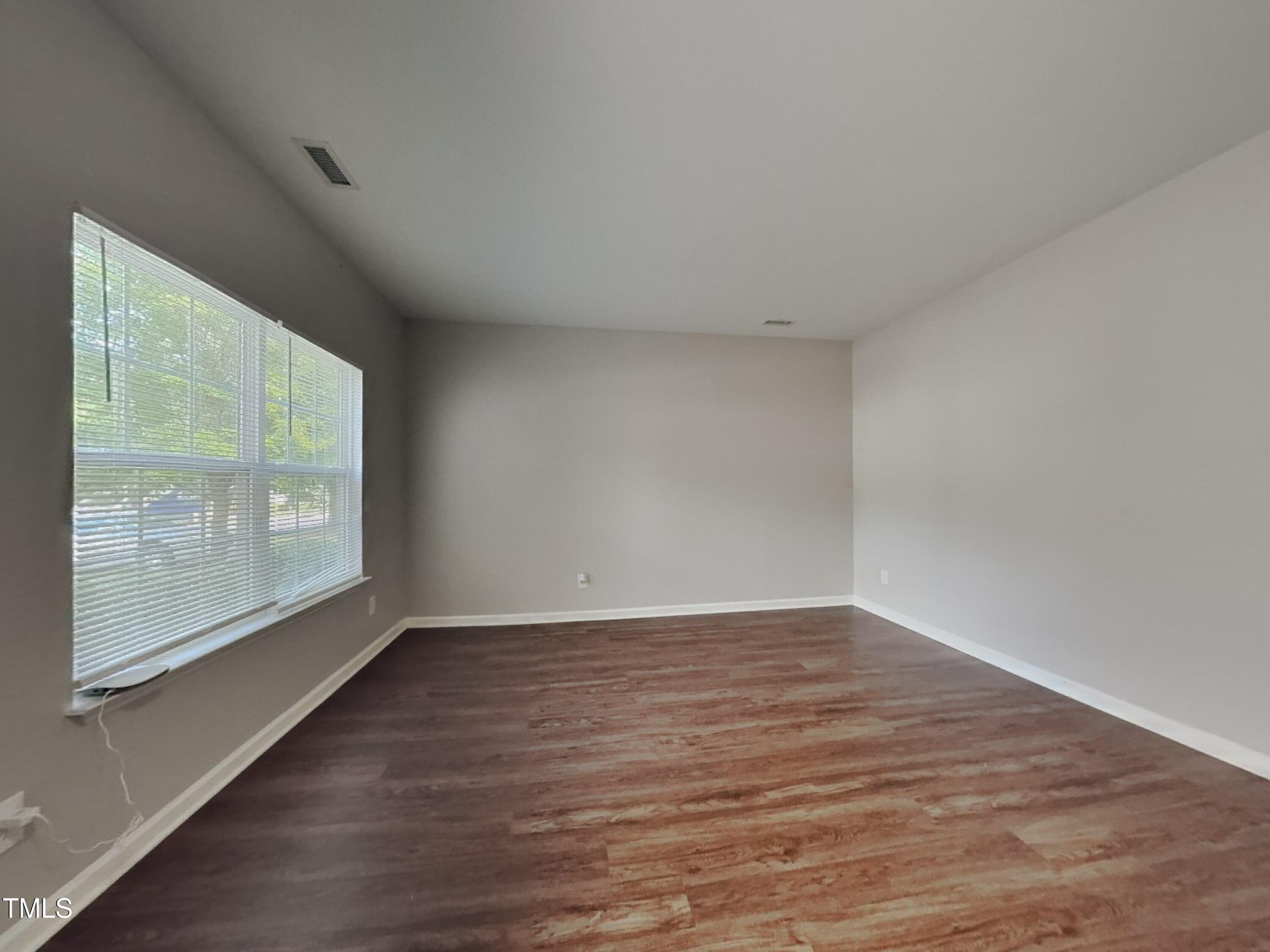 5416 Neuse Forest Road Raleigh, NC 27616 - Photo 5 of 15 a view of an empty room with wooden floor and a window
