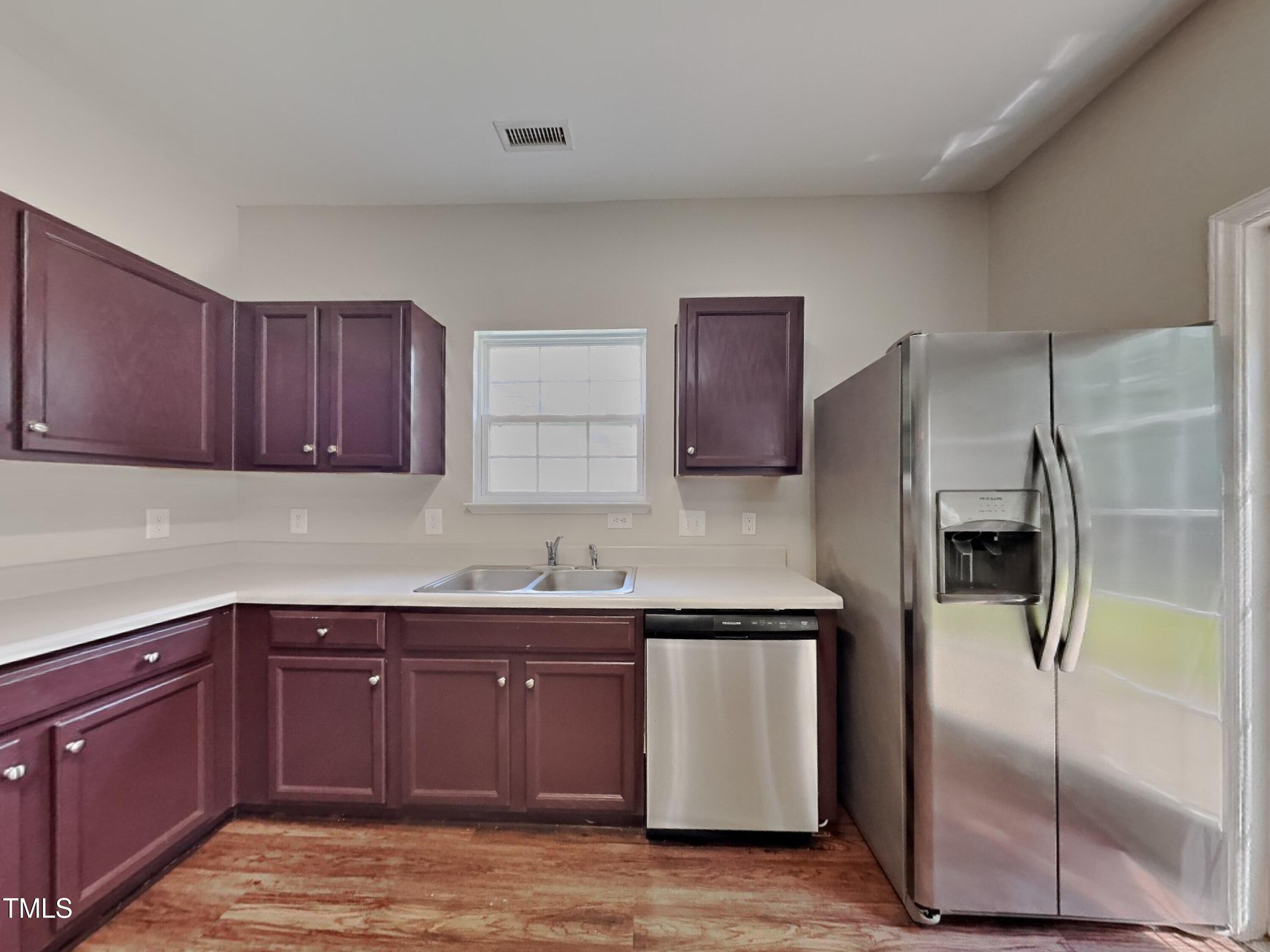5416 Neuse Forest Road Raleigh, NC 27616 - Photo 7 of 15 a kitchen with stainless steel appliances granite countertop a refrigerator a sink and dishwasher with wooden floor
