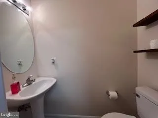 a bathroom with a sink mirror and toilet