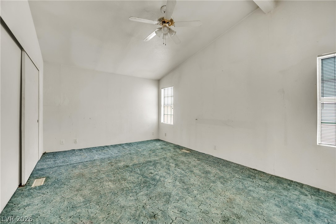 4361 Maple Road Pahrump, NV 89048 - Photo 19 of 46 A spacious bedroom offers a soaring vaulted ceiling and natural light through a clear window.