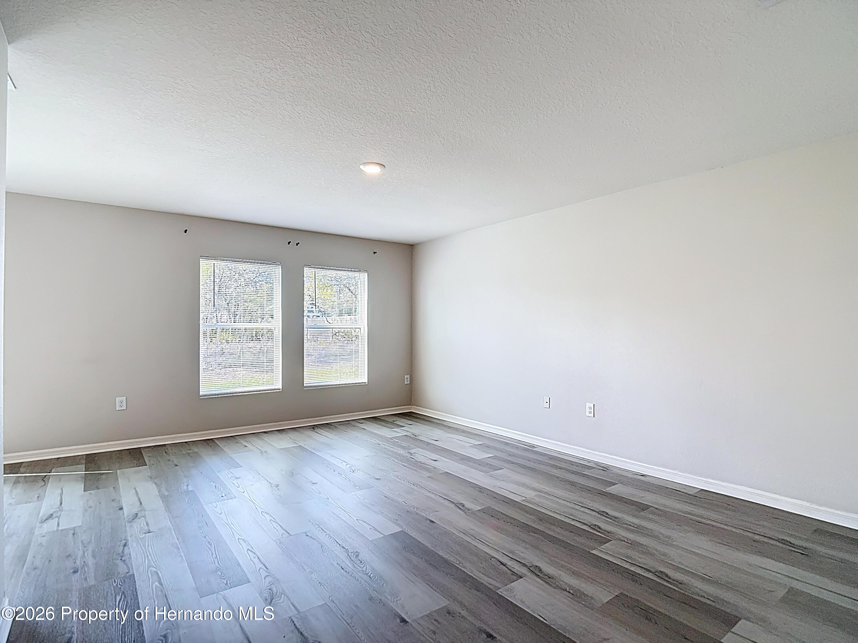11374 Marcella Avenue Weeki Wachee, FL 34614 - Photo 15 of 70 a view of an empty room with wooden floor and a window
