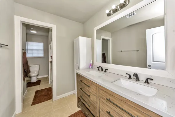 a bathroom with double vanity sinks and a mirror