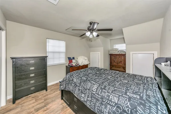 a bed room with a bed and a mirror on dresser