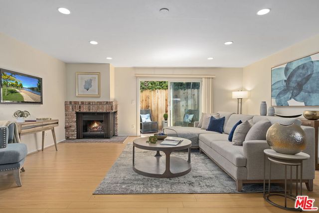 a living room with furniture a fireplace and a flat screen tv