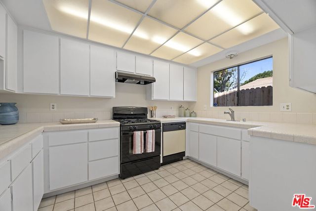 a kitchen with sink cabinets and stove