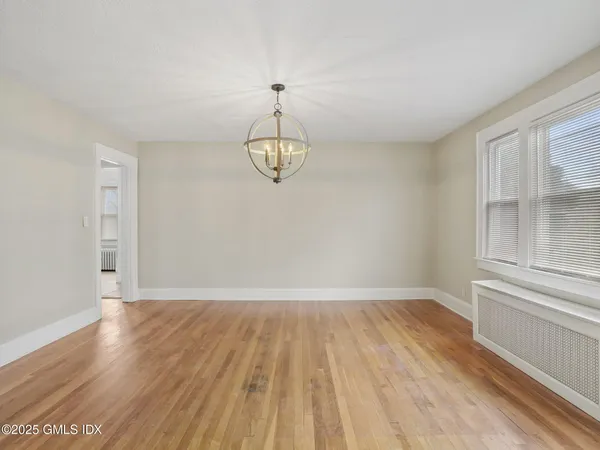 a view of a room with wooden floor and chandelier