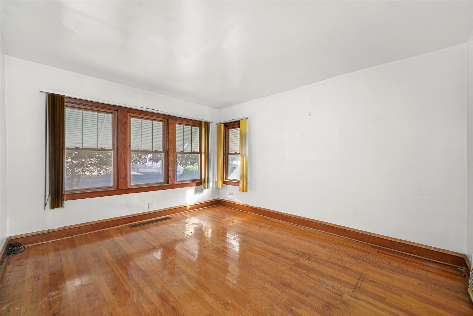 1430 South 10th Avenue Maywood, IL 60153 - Photo 4 of 29 a view of an empty room with a window and wooden floor