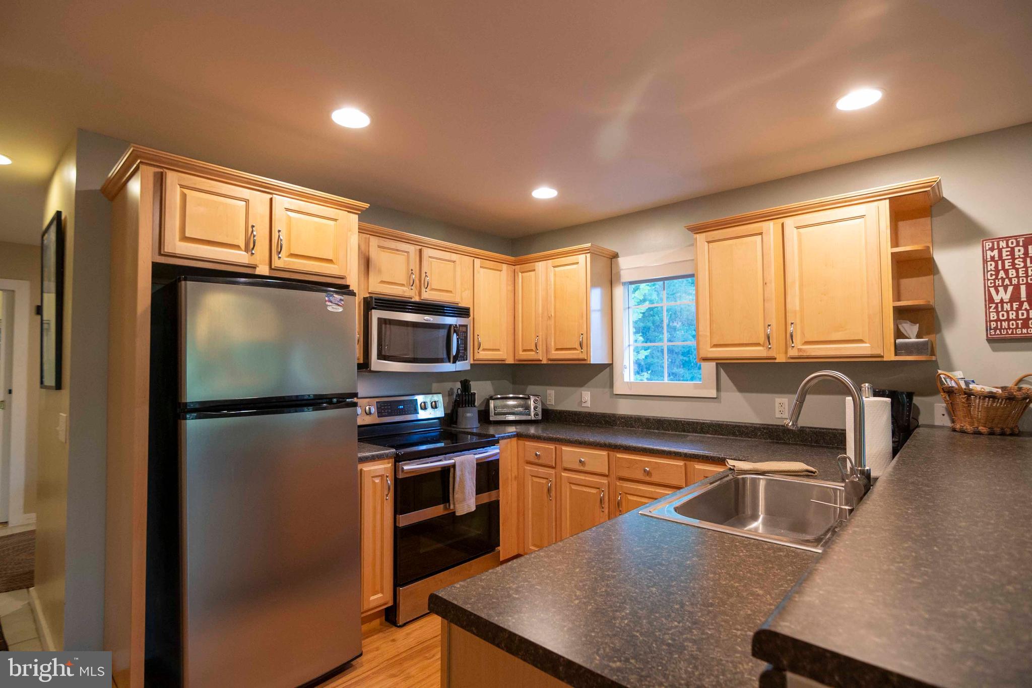 125 Fritzel Way Basye, VA 22842 - Photo 27 of 72 a kitchen with stainless steel appliances granite countertop a refrigerator a sink a stove top oven with a dining table and chairs