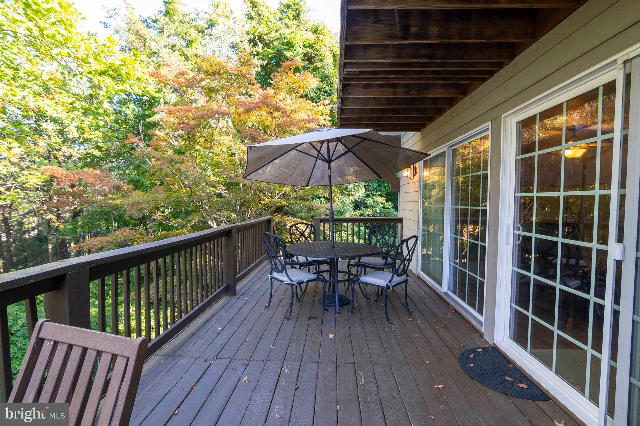 125 Fritzel Way Basye, VA 22842 - Photo 37 of 72 a view of a balcony with table and chairs under an umbrella with wooden floor