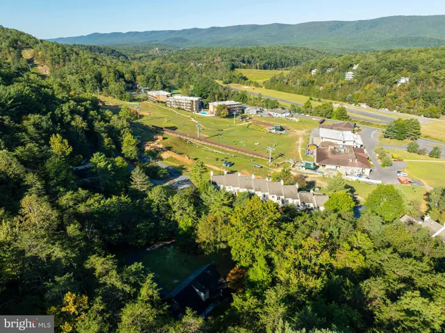 an aerial view of a house with a yard basket ball court and outdoor seating
