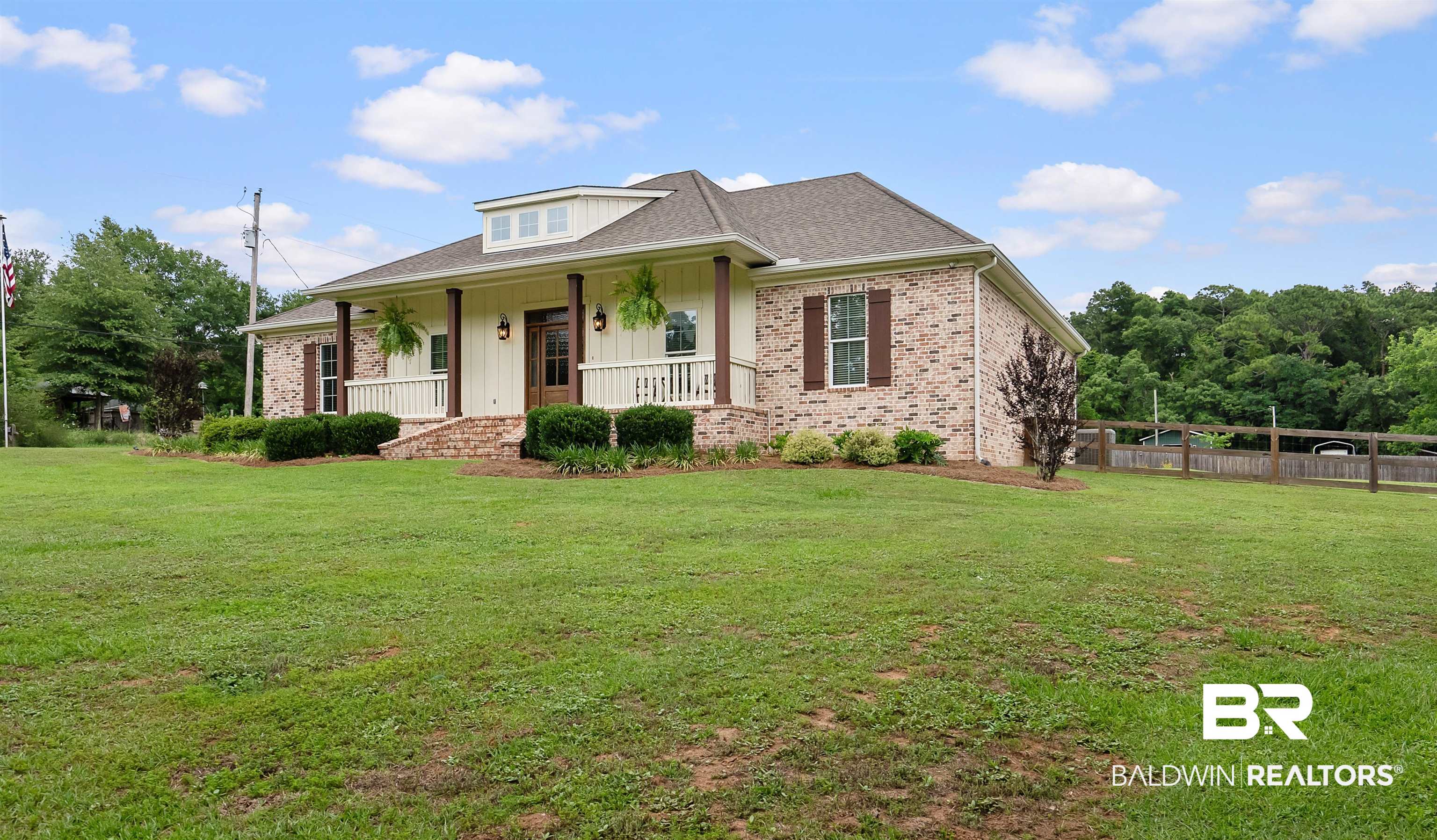 12070 Comalander Road Fairhope, AL 36532 - Photo 49 of 50 Brick exterior with a dormer, covered porch, wood columns, and dark brown shutters