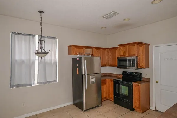 a kitchen with stainless steel appliances granite countertop a refrigerator and a stove top oven