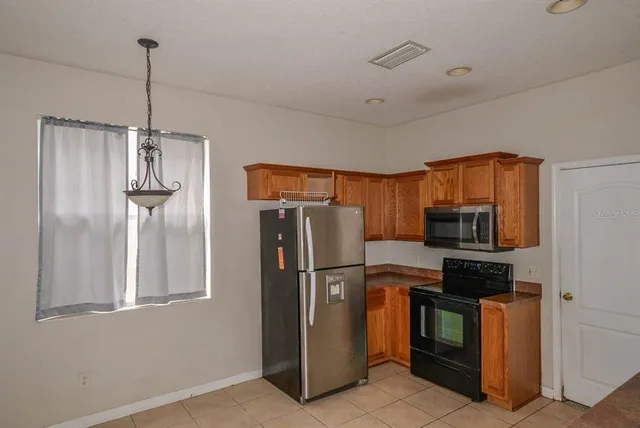 a kitchen with stainless steel appliances granite countertop a refrigerator and a stove top oven