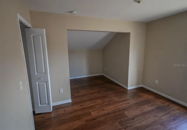 an empty room with wooden floor and closet