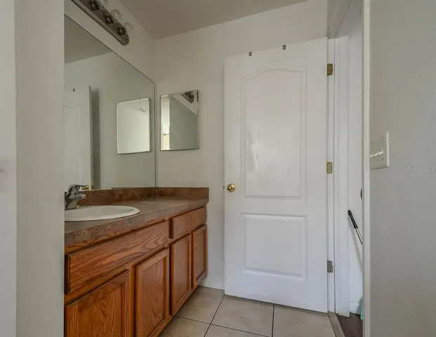a bathroom with a granite countertop sink and mirror