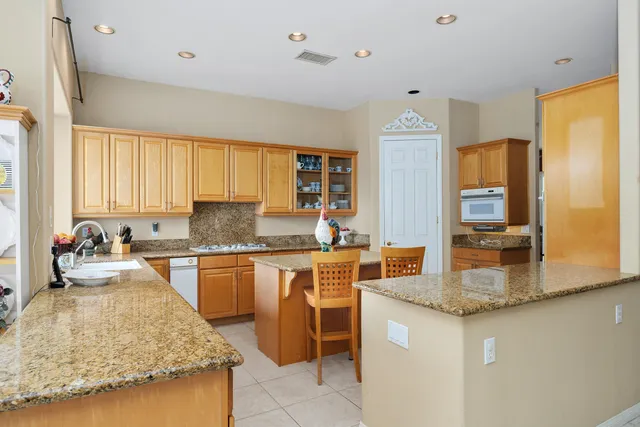 a living room with furniture appliances and a kitchen view