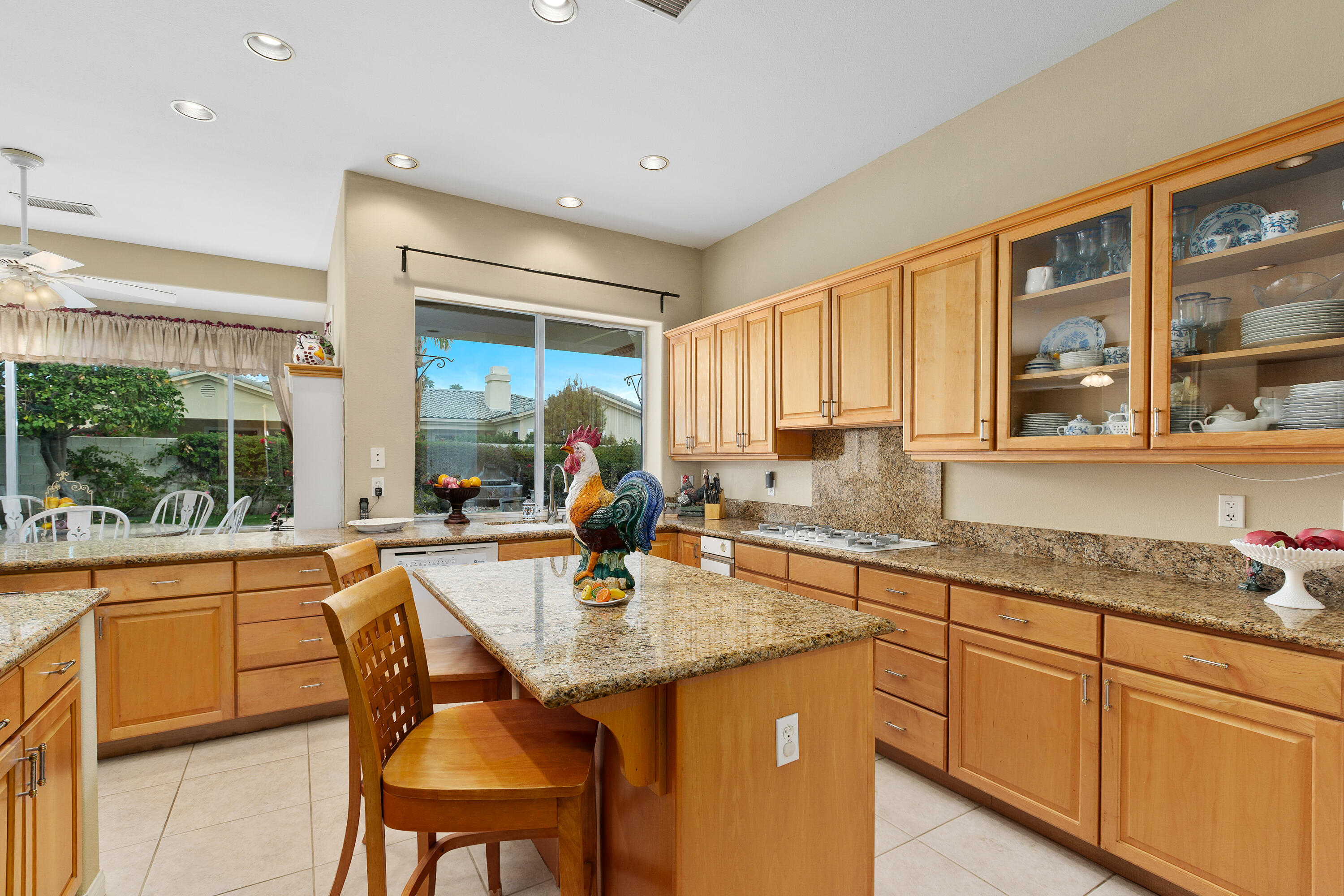 2 Othello Court Rancho Mirage, CA 92270 - Photo 19 of 45 a kitchen with granite countertop sink table and chairs