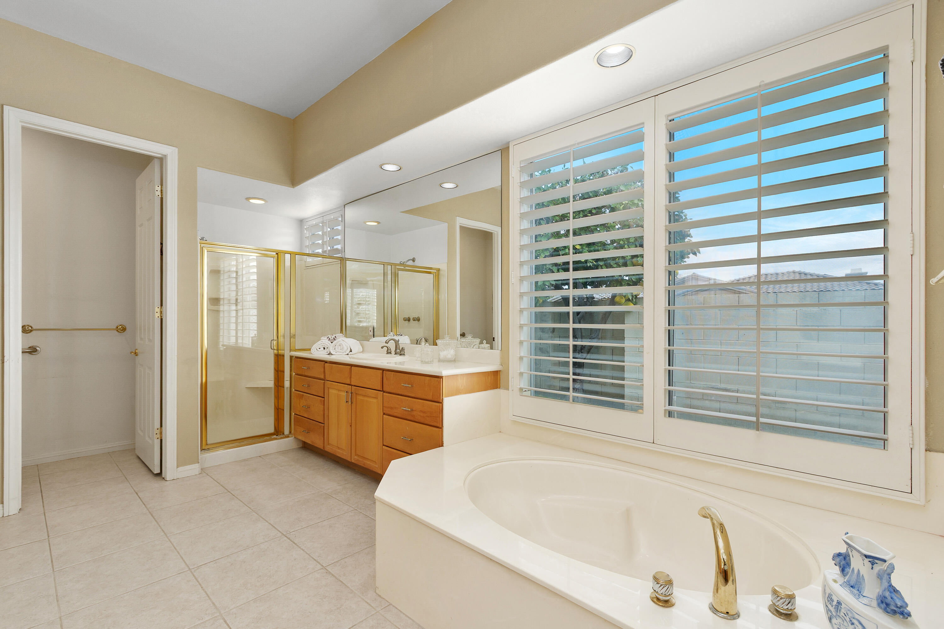 2 Othello Court Rancho Mirage, CA 92270 - Photo 30 of 45 a bathroom with a granite countertop sink a bathtub and a shower