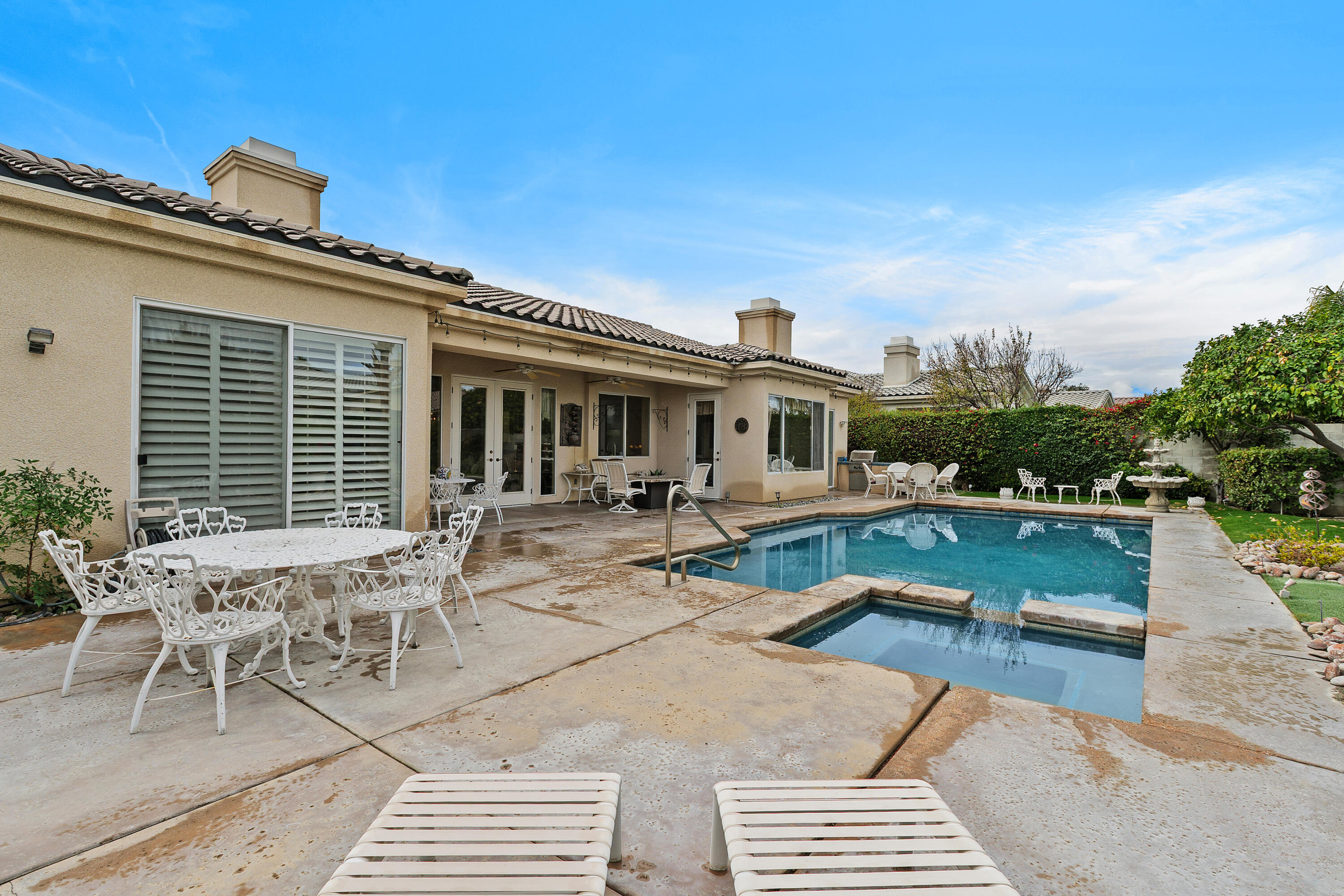 2 Othello Court Rancho Mirage, CA 92270 - Photo 32 of 45 a view of a patio with couches table and chairs with wooden floor and fence