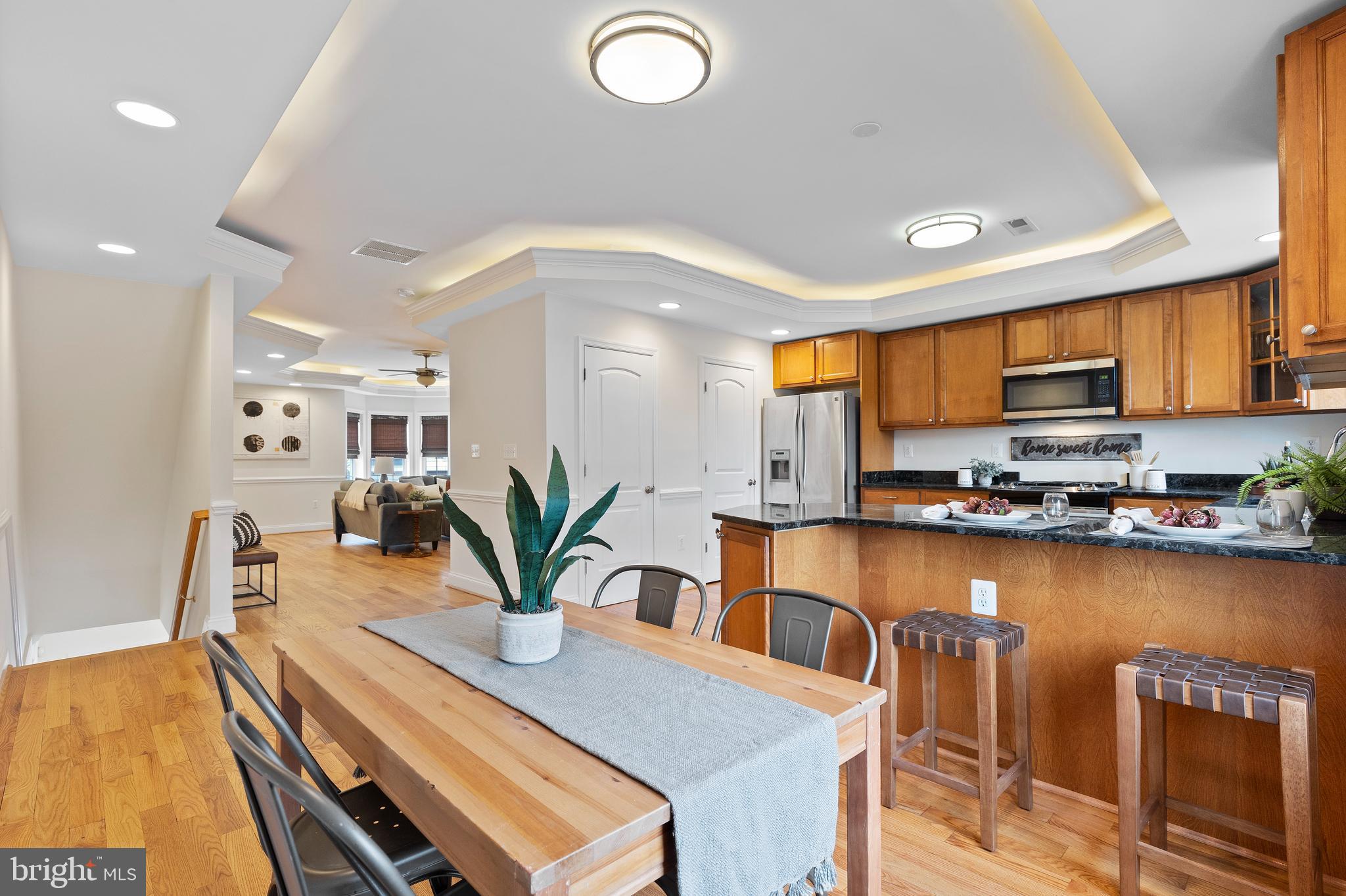 1125 Race Street Baltimore, MD 21230 - Photo 11 of 43 a kitchen with stainless steel appliances a dining table chairs in it and wooden floors