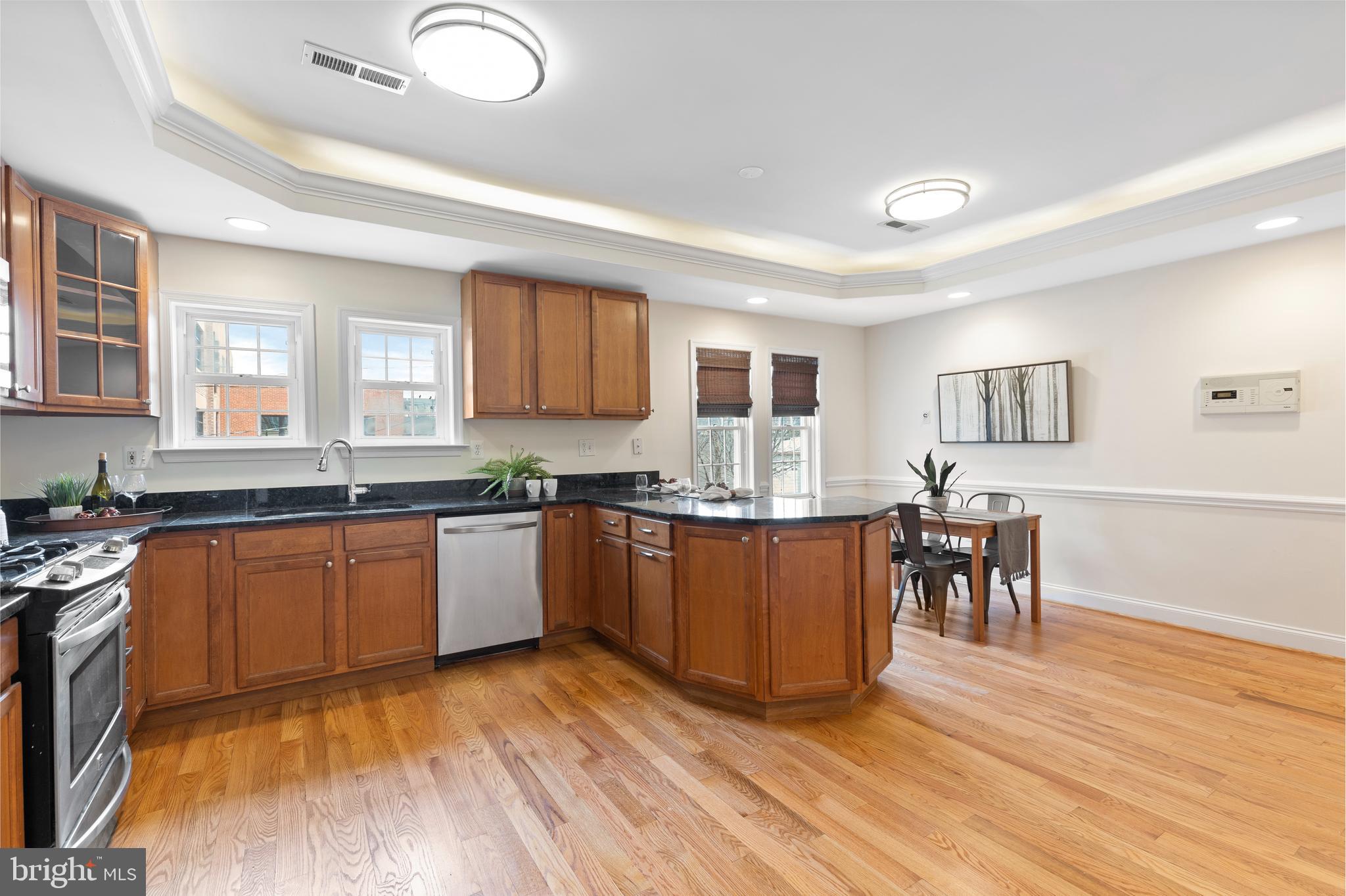1125 Race Street Baltimore, MD 21230 - Photo 8 of 43 a kitchen with stainless steel appliances granite countertop a stove top oven a sink dishwasher a dining table and chairs with wooden floor