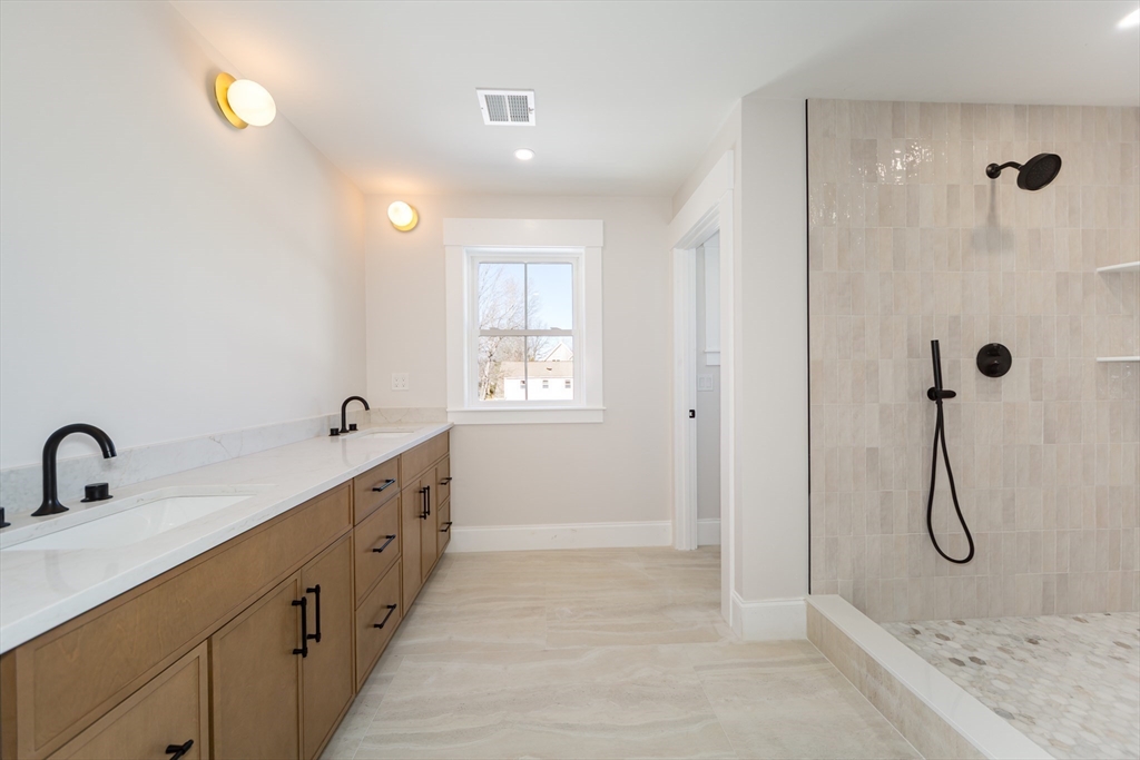 57 Beverly Road Natick, MA 01760 - Photo 16 of 20 a bathroom with a double vanity sink a shower and a bathtub