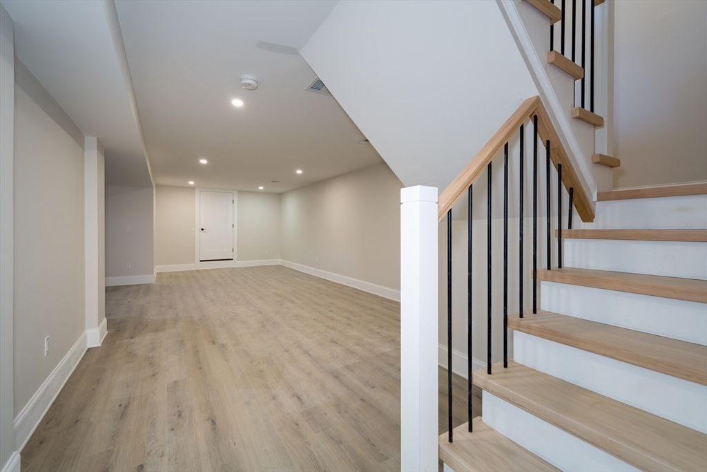 57 Beverly Road Natick, MA 01760 - Photo 18 of 20 a view of a hallway with wooden floor and staircase