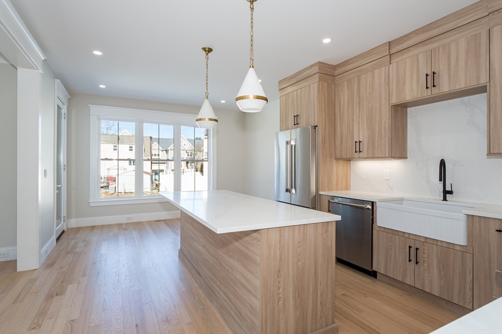 57 Beverly Road Natick, MA 01760 - Photo 7 of 20 a kitchen with stainless steel appliances granite countertop a sink a stove a refrigerator and island with wooden floor
