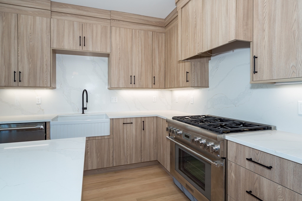 57 Beverly Road Natick, MA 01760 - Photo 8 of 20 a kitchen with stainless steel appliances granite countertop a stove a sink and a white cabinets