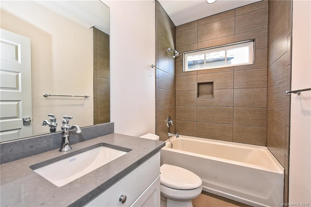 2308 Vernon Drive Charlotte, NC 28211 - Photo 16 of 24 a bathroom with a granite countertop sink toilet mirror and bathtub