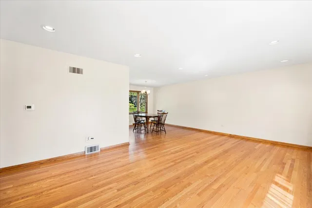 a view of a room with wooden floor and a table