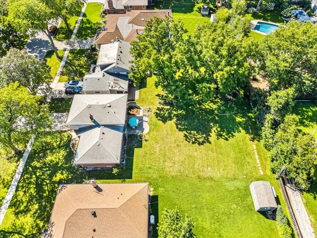 an aerial view of residential houses with outdoor space and trees
