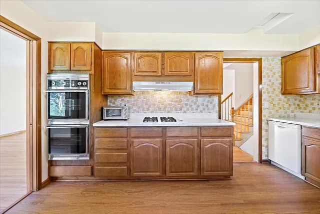 a kitchen with stainless steel appliances granite countertop a stove a sink and a microwave