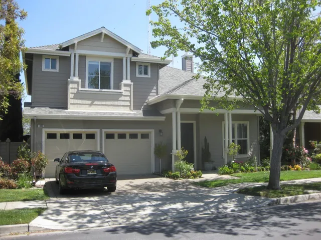 a car parked in front of a white house