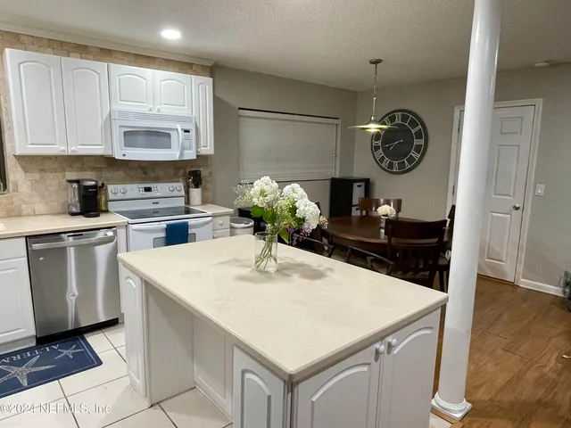 a kitchen with white cabinets and white appliances
