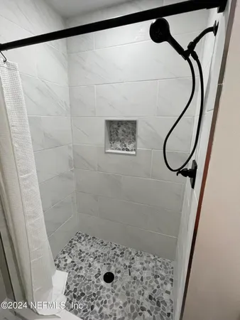 a bathroom with a shower and a mirror