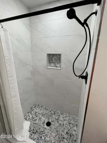 a bathroom with a shower and a mirror