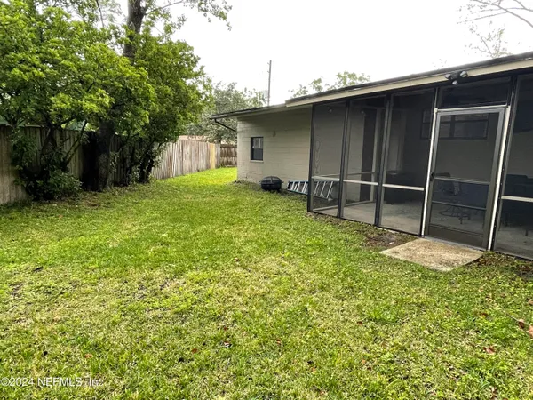 a view of a yard with wooden fence