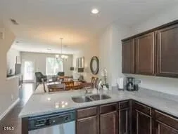 a kitchen with kitchen island granite countertop a sink dishwasher stove and cabinets
