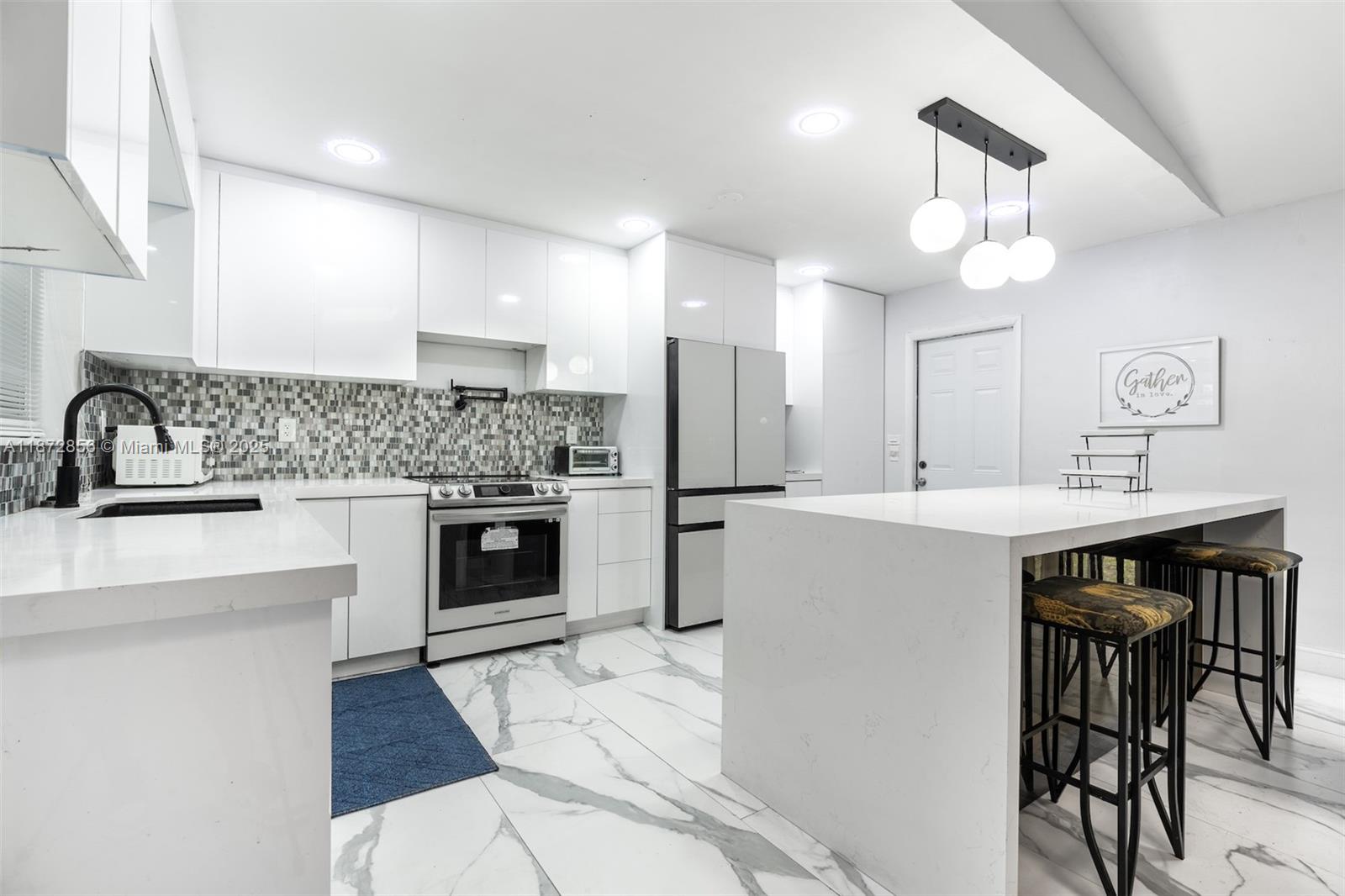 18525 Northwest 39th Avenue Miami Gardens, FL 33055 - Photo 4 of 11 a kitchen with kitchen island a sink stainless steel appliances and cabinets