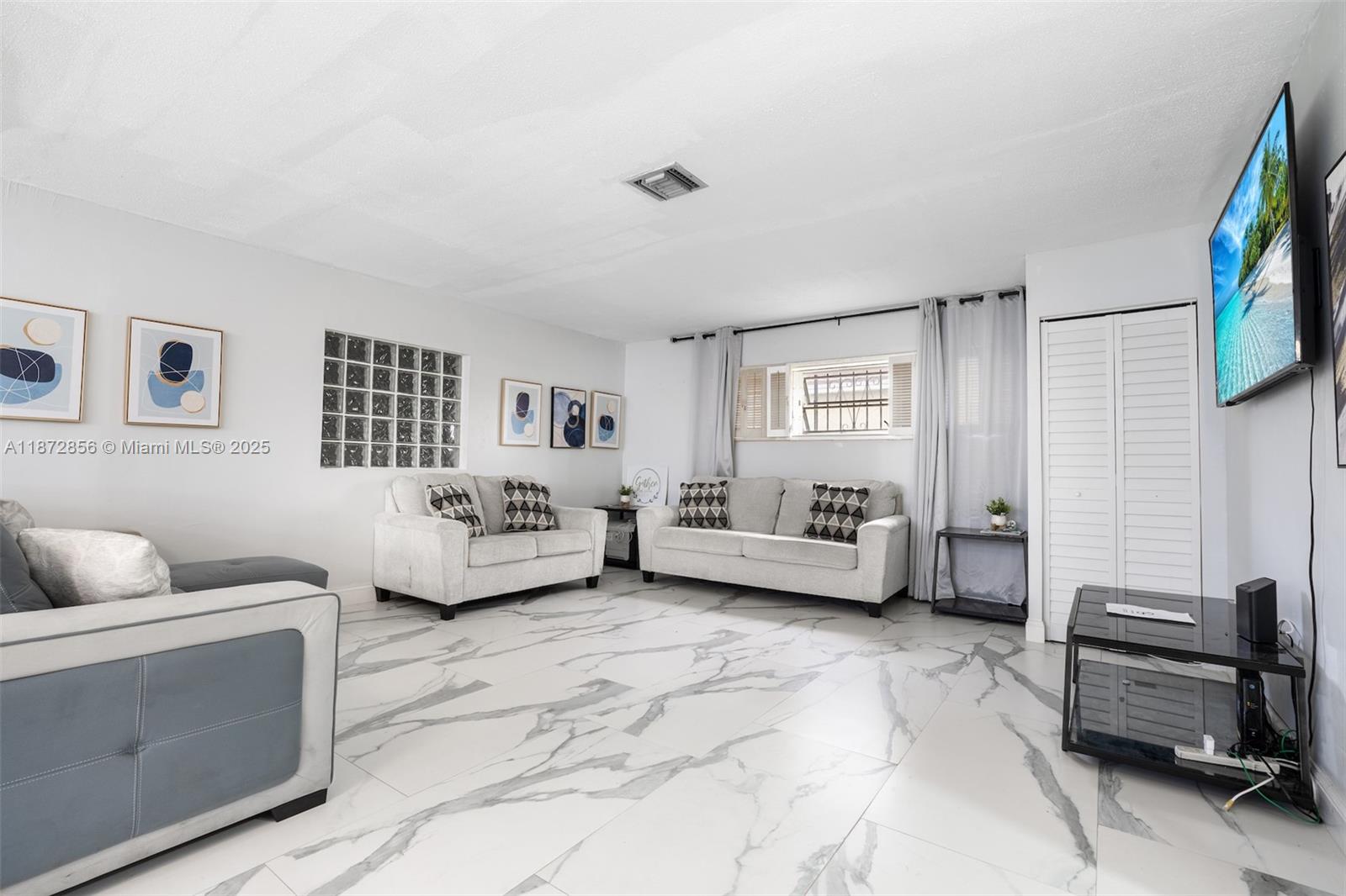 18525 Northwest 39th Avenue Miami Gardens, FL 33055 - Photo 6 of 11 a spacious bedroom with a bed and a couch