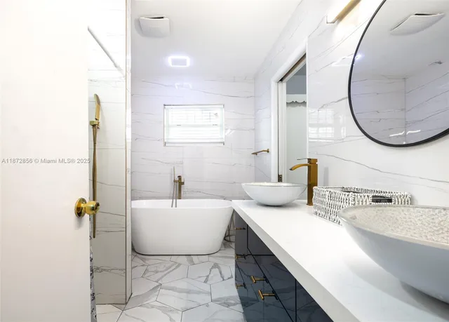 a bathroom with a granite countertop sink mirror and bathtub