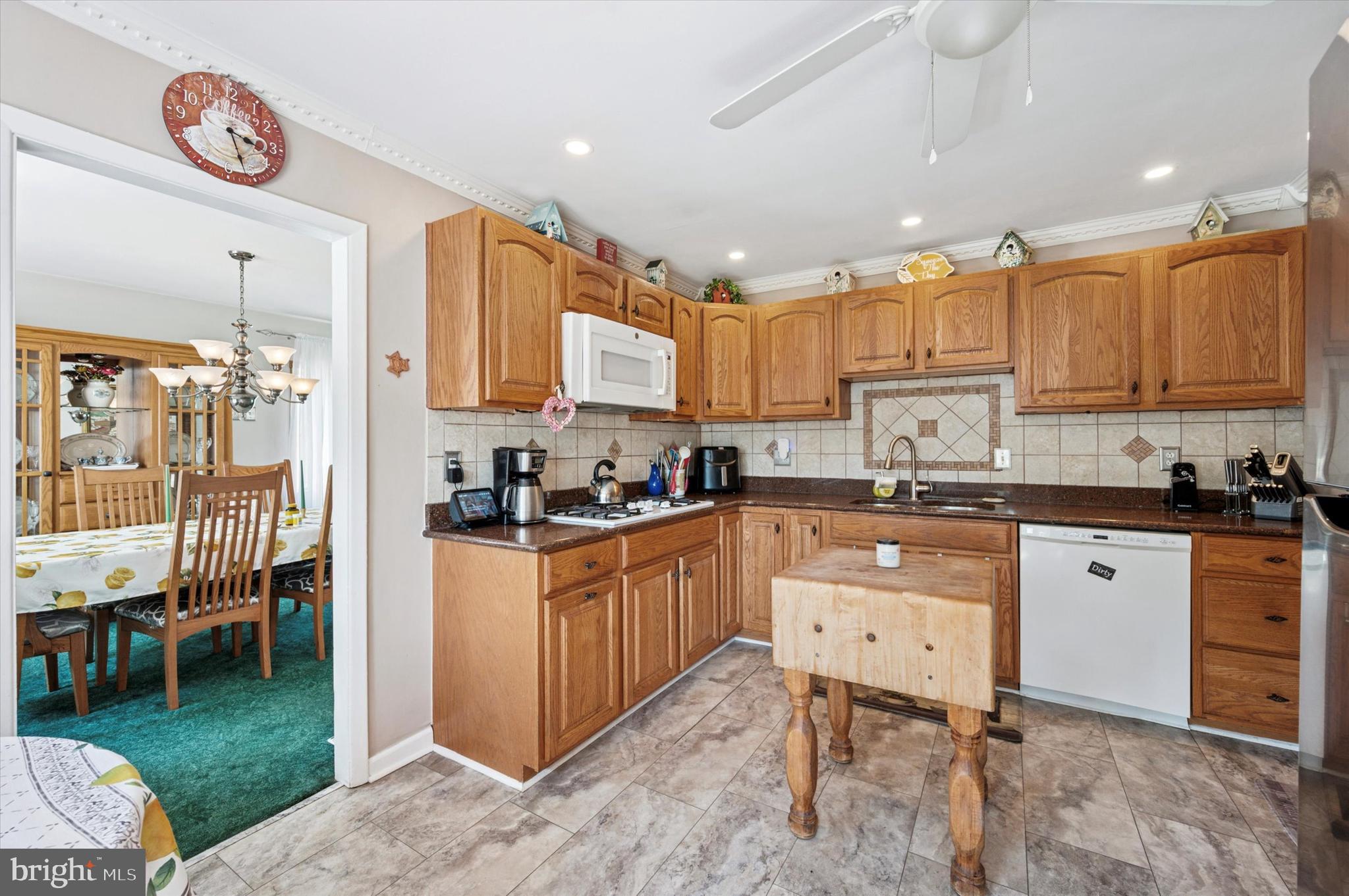 1007 Glen Road Wallingford, PA 19086 - Photo 17 of 50 a kitchen with granite countertop a table chairs stove top oven and cabinets