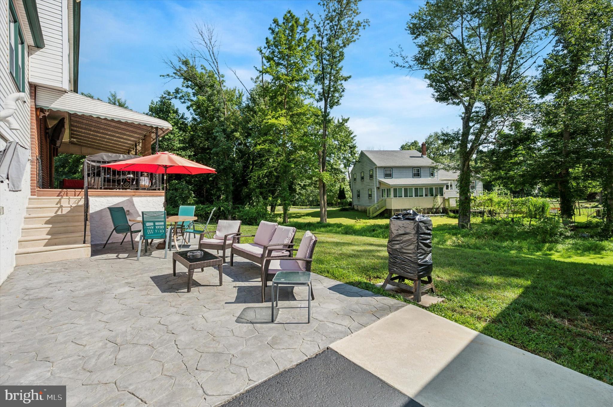 1007 Glen Road Wallingford, PA 19086 - Photo 47 of 50 a view of a patio with a table and chairs under an umbrella